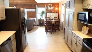 A kitchen with wooden cabinets, a dining area with a chandelier, and a microwave on the countertop. - Lakefront with
Stunning Views! (Creal Springs)