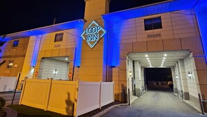A hotel entrance with a 'LOOP INN' sign, a gated driveway, and a well-lit entrance area.
