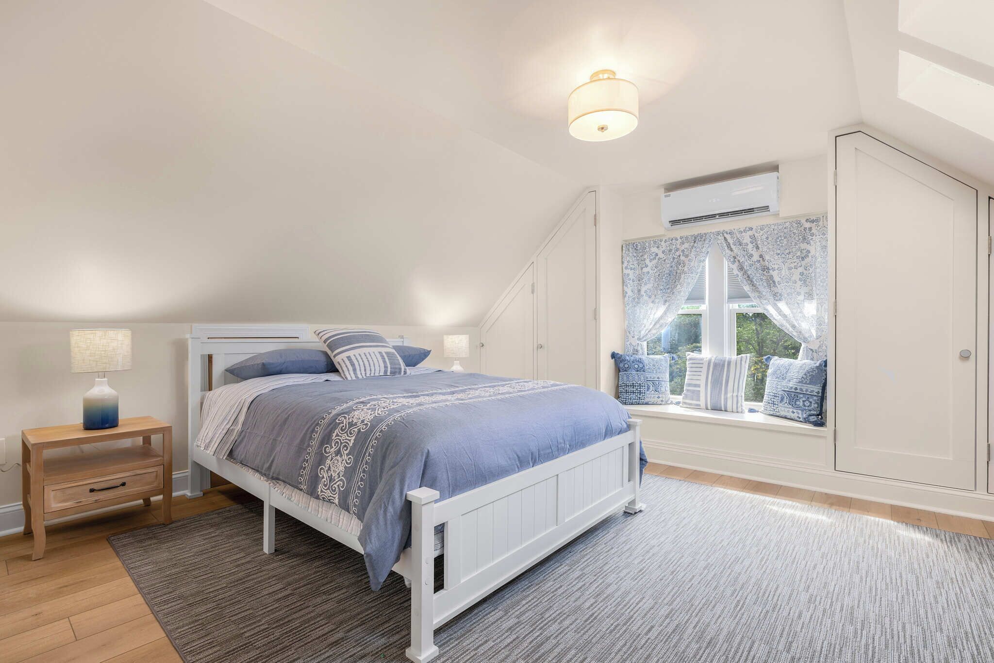 Un dormitorio con cama, mesita de noche y ventana con vistas.