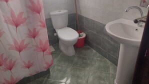 A bathroom with a toilet, a sink, and a shower curtain. - La bonita compound  (Hurghada)