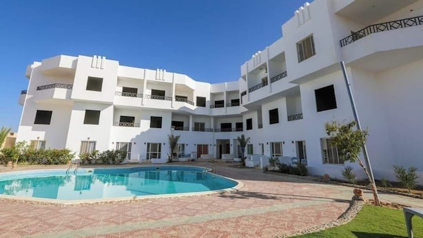 A white multi-story building with a swimming pool in the courtyard. - La bonita compound  (Hurghada)