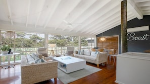 A spacious living area with wicker furniture, a white coffee table, and a ceiling fan. - 10 minute walk to Copacabana Beach, shops and cafes (Copacabana)
