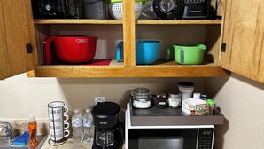 A kitchen with a microwave, coffee maker, and various kitchen utensils on the counter. - Eagle Stay 7 Condo-Eagle Pass (Eagle Pass)