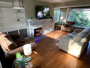 A living room with a fireplace, a television, and a sofa.