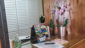 Un escritorio de madera con un tablón de anuncios, una planta en maceta, una libreta y un bolígrafo.