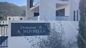 A modern building with a sign that reads "Domaine di A Muvrella." - new luxury residence (1 bedroom) Sea view, Citadel and port of Calvi (Calvi)