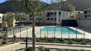 A pool area with a palm tree, surrounded by a modern building with balconies. - new luxury residence (1 bedroom) Sea view, Citadel and port of Calvi (Calvi)