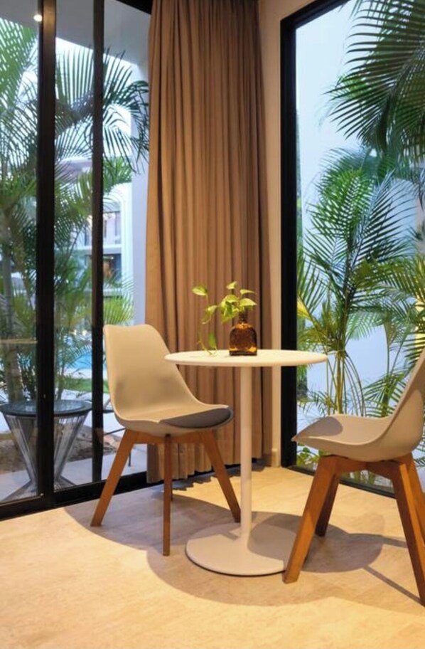Enjoy a serene view of palm trees and a nearby building from the large window in this stylish room.