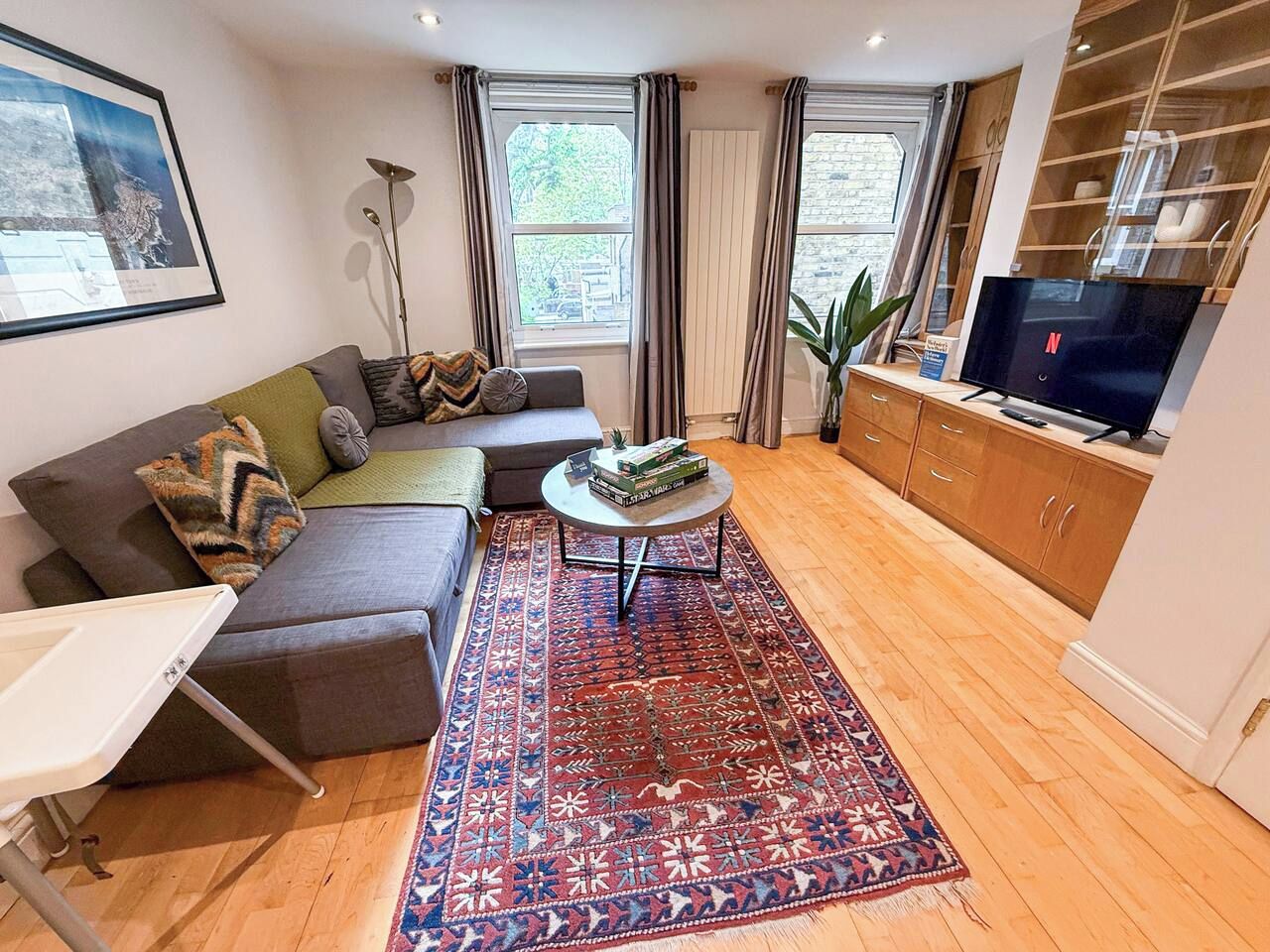 A living room with a sofa, a coffee table, a rug, and a TV.
