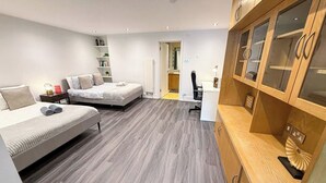 Un dormitorio moderno con dos camas, un escritorio y armarios empotrados de madera.