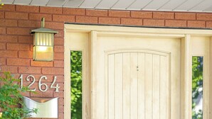 A wooden double door with a number plaque '1264' and a wall-mounted light fixture.