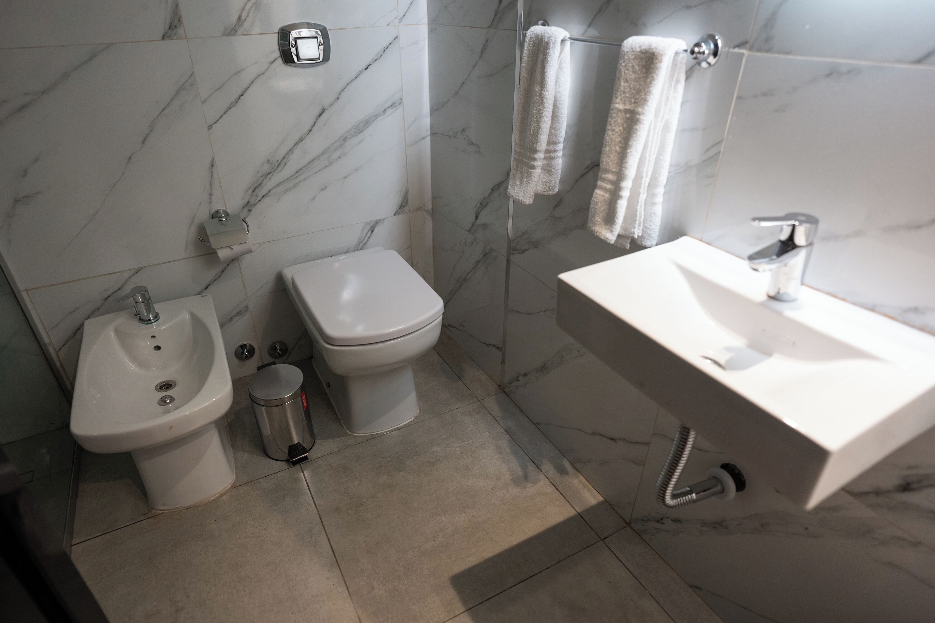 A modern bathroom with a bidet, toilet, and sink.