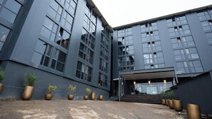 A modern building with large windows and a covered entrance. - Hotel Vuriloche Suites (San Carlos de Bariloche)
