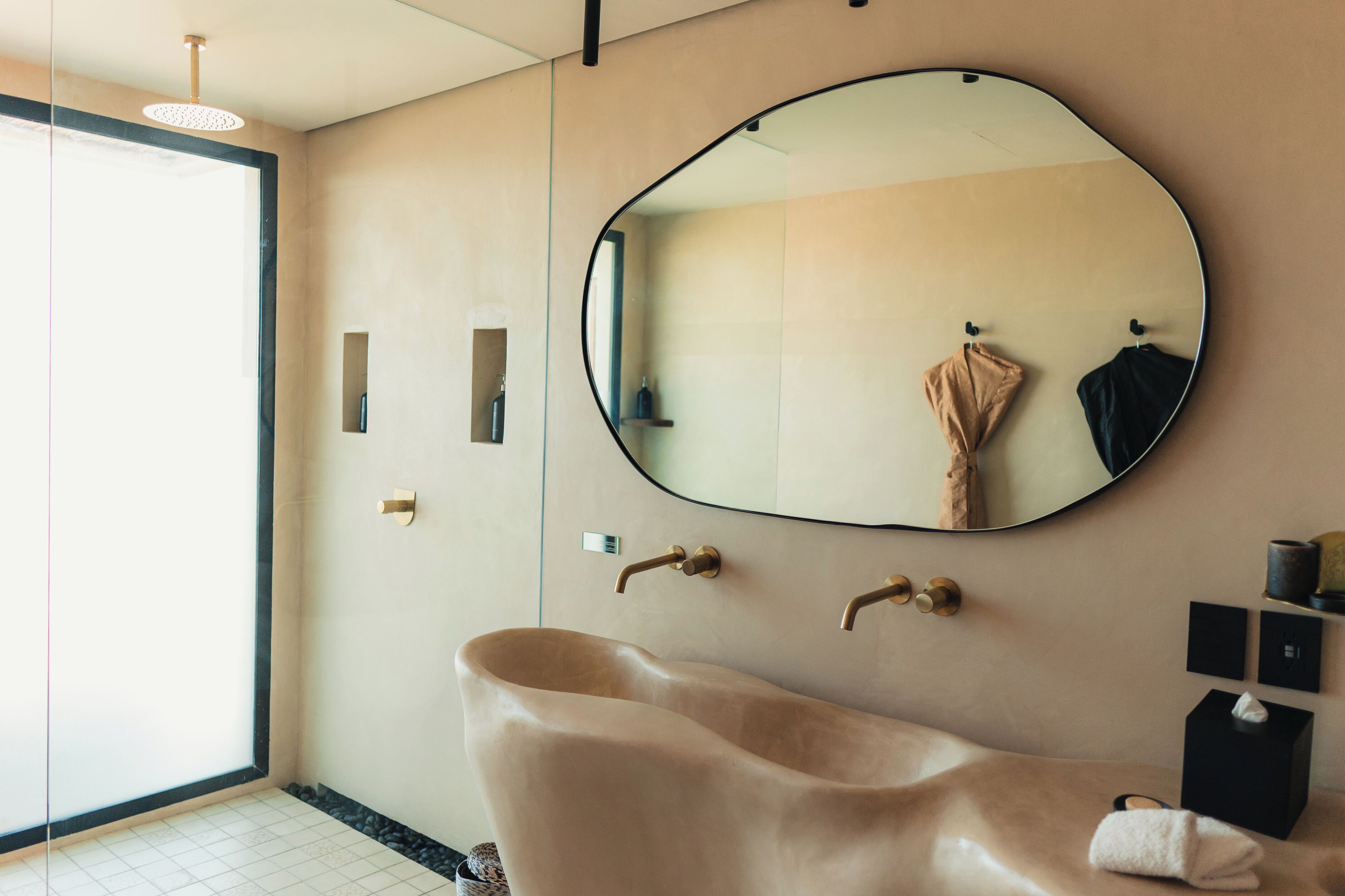 A modern bathroom with a freestanding bathtub, a large mirror, and a towel rack.