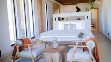 A modern bedroom with a large bed, two side tables, and a chair.