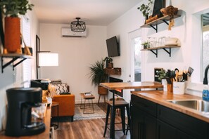 A modern kitchen with a wooden countertop, a built-in stove, and a hanging light fixture.