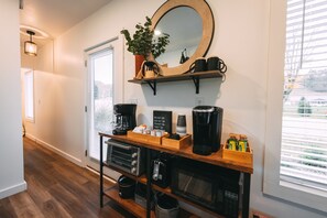 Una cocina con encimera de madera, cafetera, tostadora y microondas.