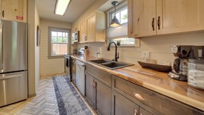 A kitchen with wooden cabinets, a stainless steel refrigerator, a sink, and a coffee maker. - < 1 Mi to Dtwn: Home w/ Deck in Clarkdale! (Clarkdale)