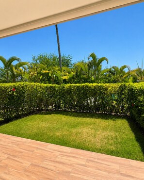 A well-maintained garden with a variety of tropical plants and a neatly trimmed hedge. - 2JA Management Group - White Hill Condos (Sosúa)