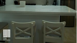 Una cocina moderna con armarios blancos, una isla central y un microondas integrado.