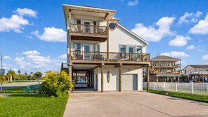 Ein zweigeschossiges Wohnhaus mit Balkon, Garage und auffälligem Auffahrtsweg.