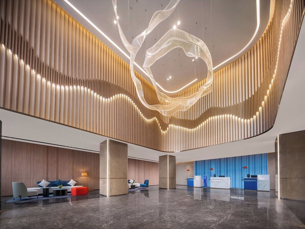 A modern lobby with a reception desk, seating area, and decorative lighting. - Holiday Inn Express Nanjing Jiangbei Wonhall Mall by IHG (Nanjing)