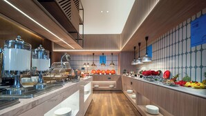 Un espace buffet moderne, doté d’un intérieur en bois, d’appareils en acier inoxydable et offrant une grande variété de plats.