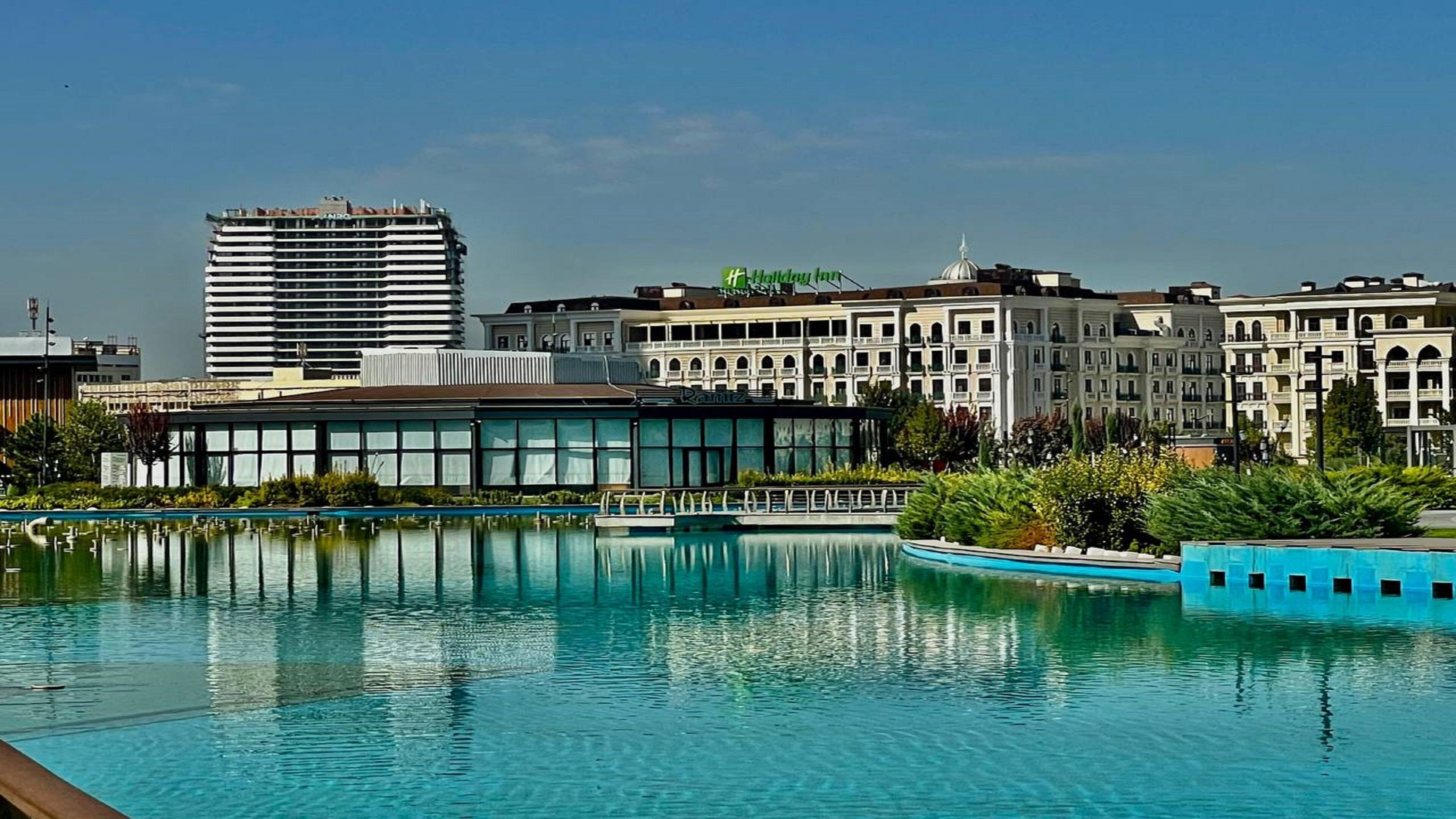 A hotel with a pool, modern architecture, and a Holiday Inn sign.