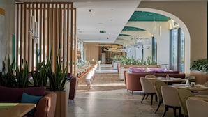 A modern restaurant interior with wooden partitions, marble flooring, and a variety of seating options including booths and tables. - Holiday Inn Tashkent City by IHG (Tashkent)