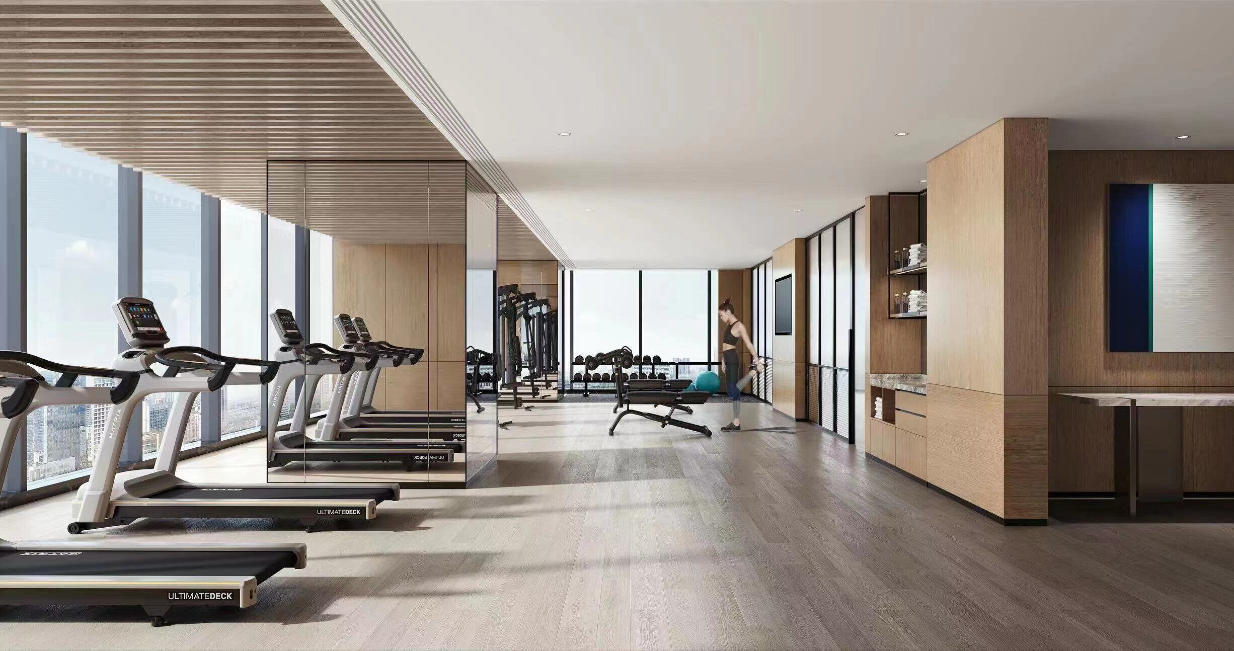 Une salle de sport moderne équipée de tapis de course, de poids et d’un murmiroir.