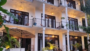 A multi-story building with balconies, a swimming pool, and potted plants. - The Jini House - Kabalana (Ahangama)