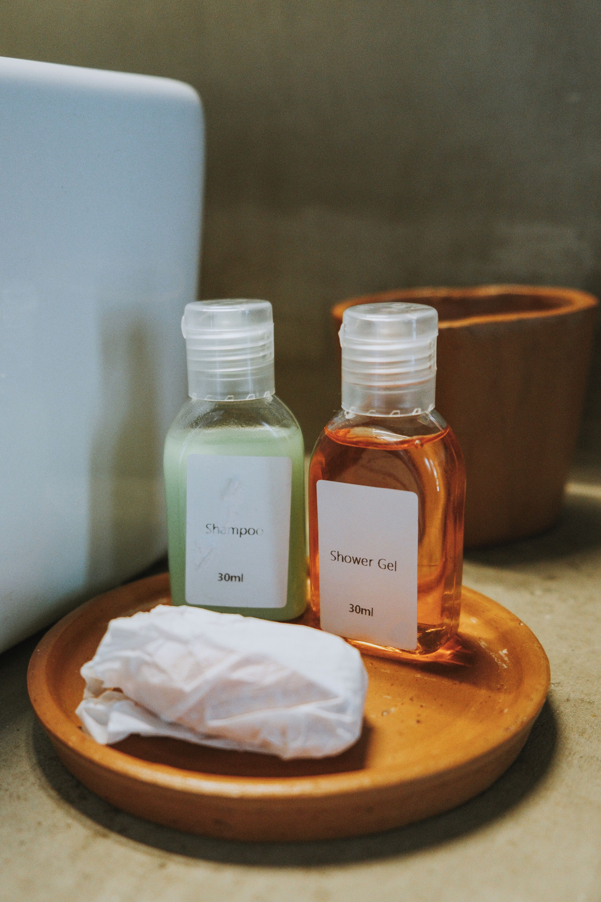 Dos botellas de champú y gel de ducha sobre una bandeja de madera.