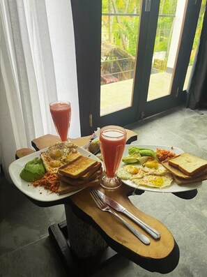 Ein Frühstückstisch mit Toast, Eiern und einem Smoothie auf Holz.