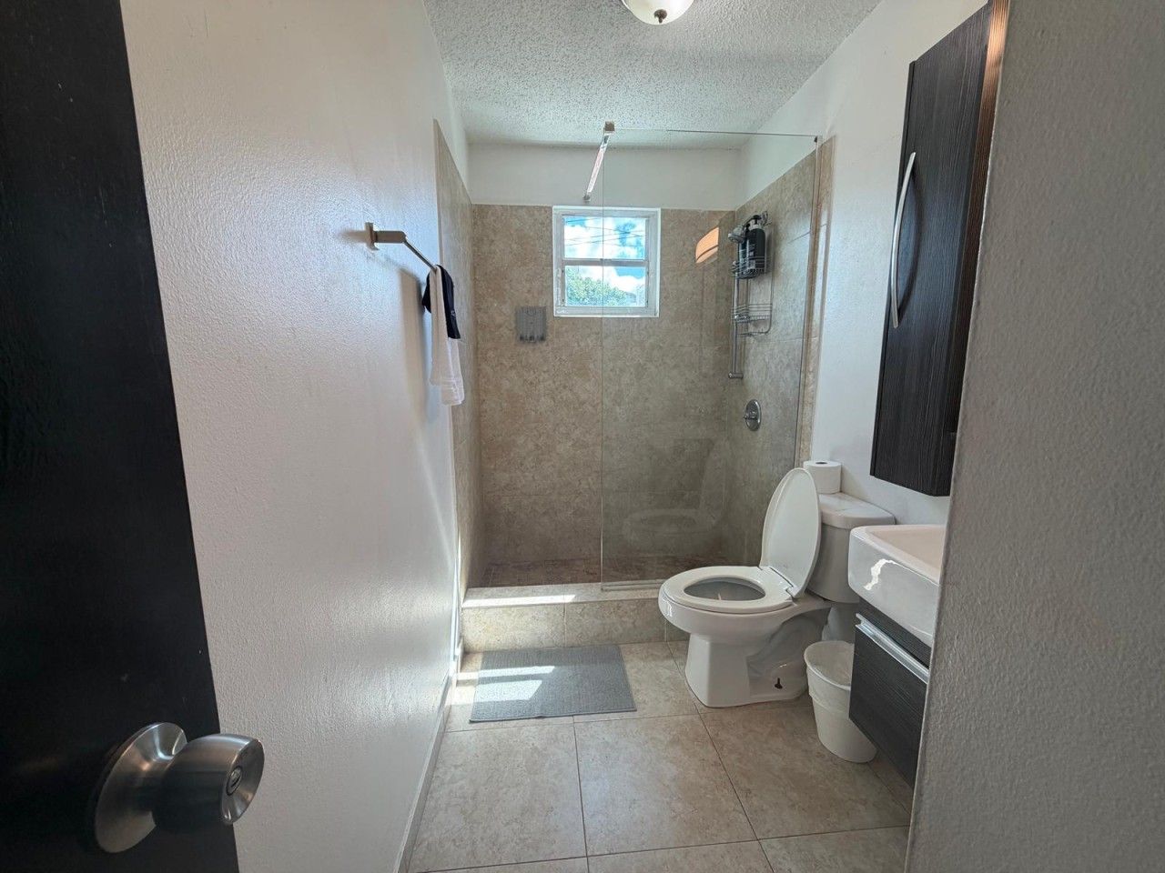 A bathroom with a shower, toilet, and sink.