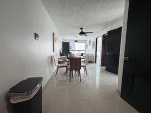 A modern interior with a dining area, a ceiling fan, and a black door. - Bright, Comfy Apt @ Miramar (San Juan)