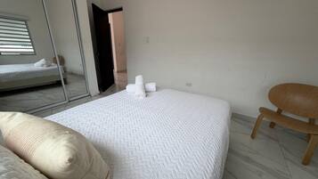 Une chambre à coucher avec un lit, une chaise et un miroir.