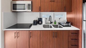 Une cuisine moderne dotée de meubles en bois, d’un four à micro-ondes, d’une machine à café et d’un lave-vaisselle.