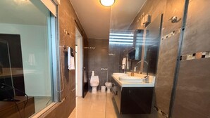 Une salle de bain moderne avec une douche à parois de verre, un meuble-lavabo avec un miroir et des toilettes.