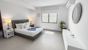 A modern bedroom with a bed, bedside tables, a mirror, and a window. - Spacious and Modern Villa with Pool in Ocean Park (San Juan)