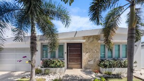 A modern house with a front door, two windows, and a garage door. - Spacious and Modern Villa with Pool in Ocean Park (San Juan)
