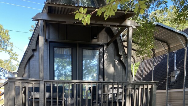 A wooden cabin with a balcony, a fire pit, and kayaks stored underneath. - Kayak Cottage - Free kayaks and fire pit (Lampe)