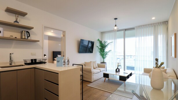 A modern apartment with a kitchen, living area, and dining space.