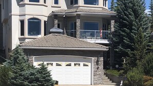 Une maison à deux étages avec un garage, un balcon et une allée.