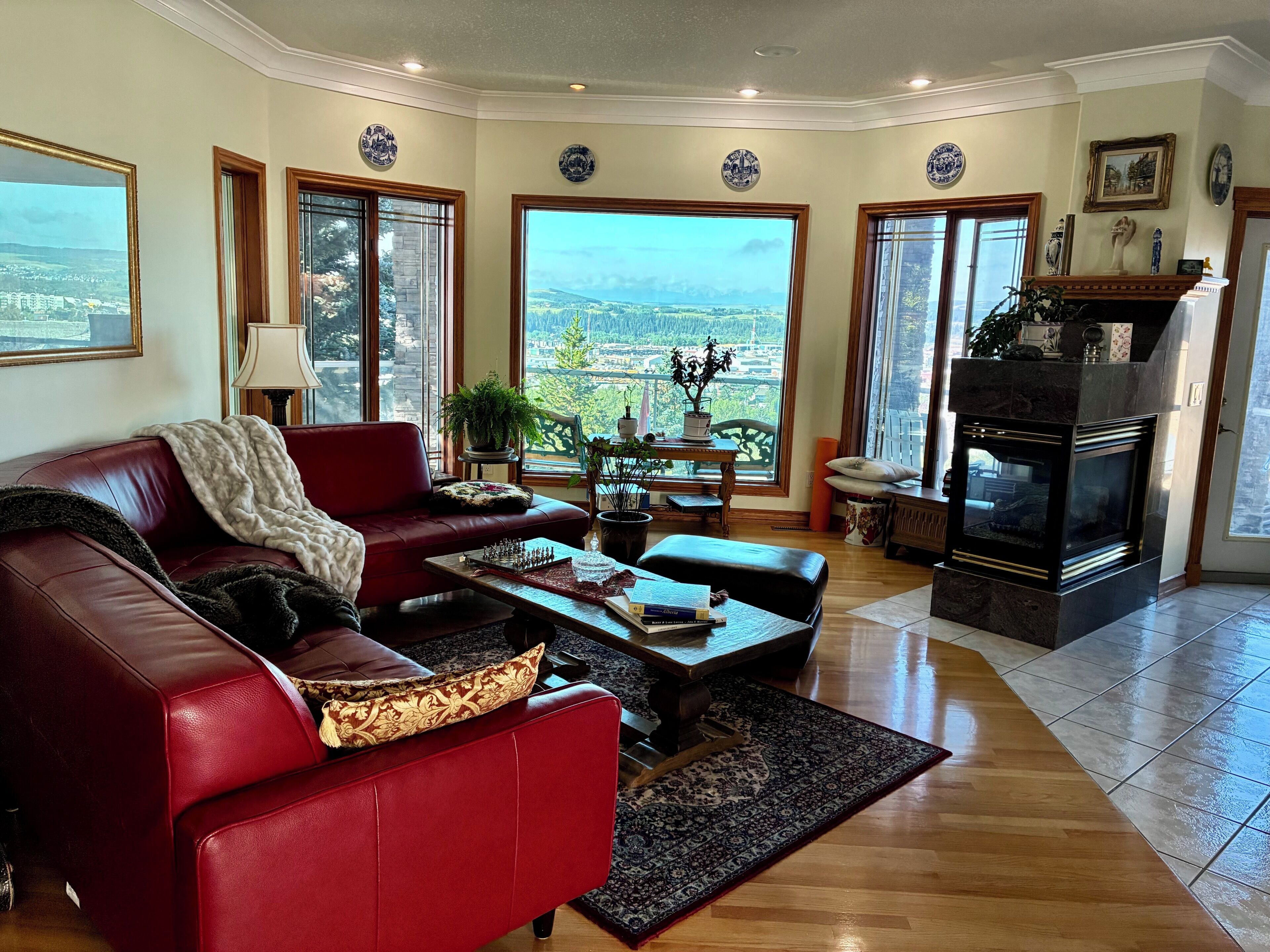 Una sala de estar con un sofá rojo, una mesa de centro y una chimenea.