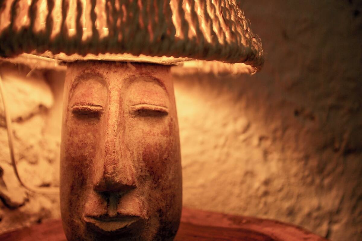 Un objet rustique, à la texture marquée et au sommet arrondi, qui pourrait être un élément décoratif ou un artefact.