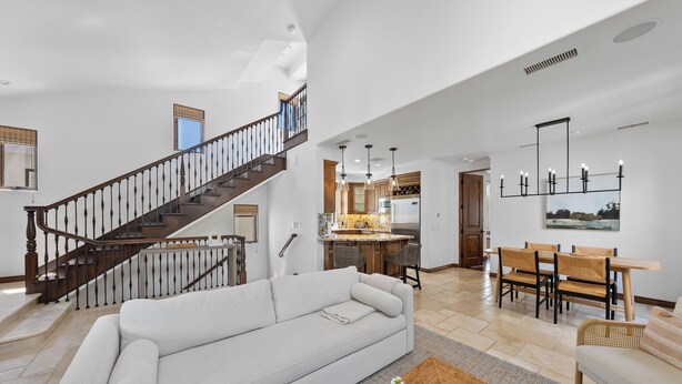 A spacious living area with a staircase, a dining area, and a kitchen. - Luxury Coastal Home with Rooftop Deck & Ocean Views in Newport Beach (Newport Beach)