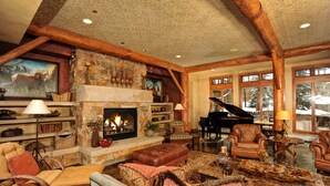 Un salon spacieux doté d’une cheminée, d’un piano à queue et de sièges confortables.