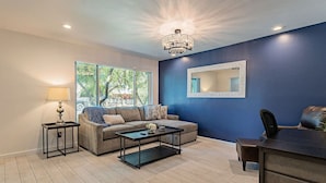Un salon moderne comprenant un canapé, une table basse et un bureau avec une chaise.