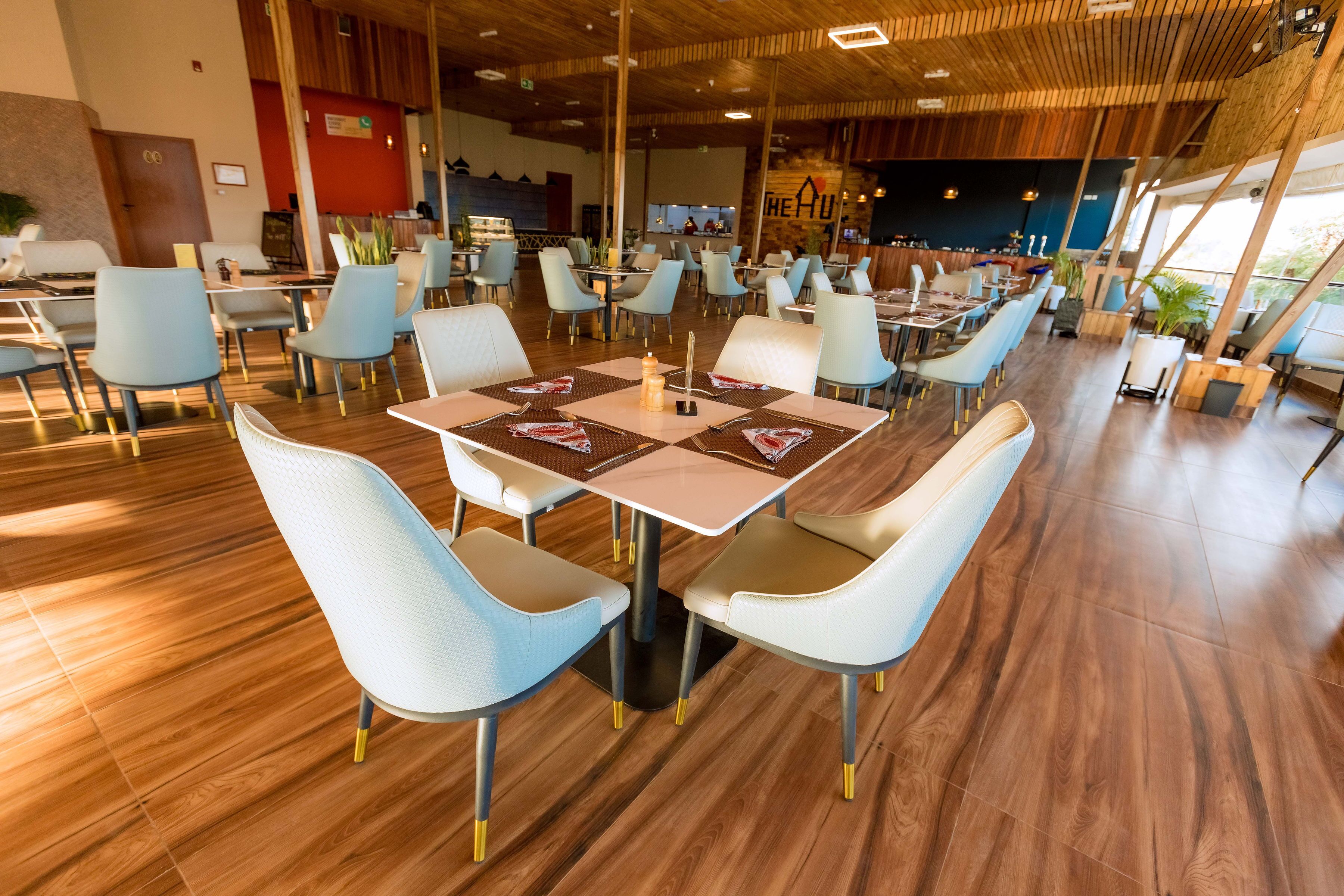 A spacious restaurant with modern furniture, a bar area, and a view of the outdoors.