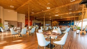 A spacious dining area with wooden ceiling and modern chairs. - The Hut Restaurant & Boutique hotel (Kigali)